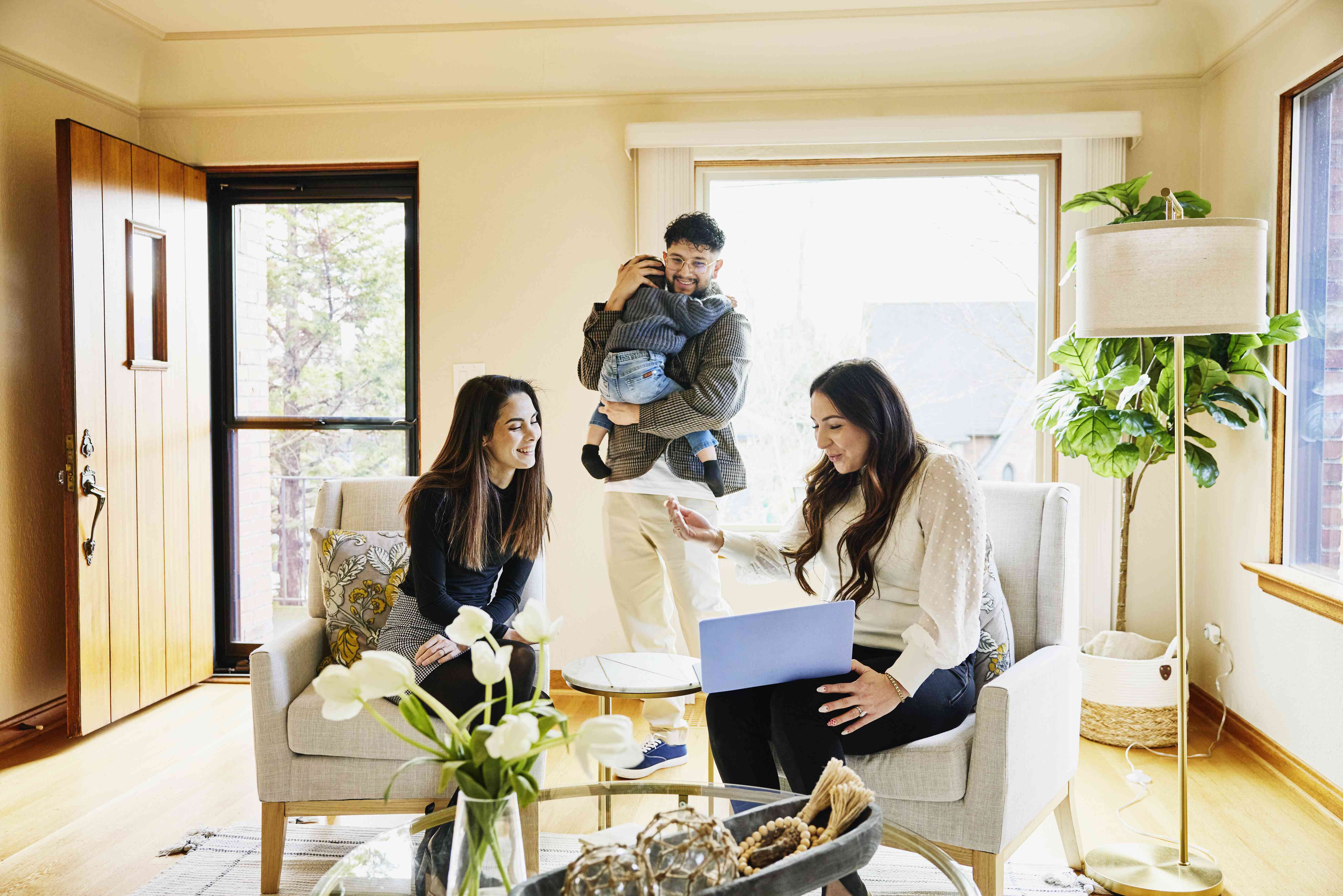 Family with toddler choosing an online stock broker on a laptop