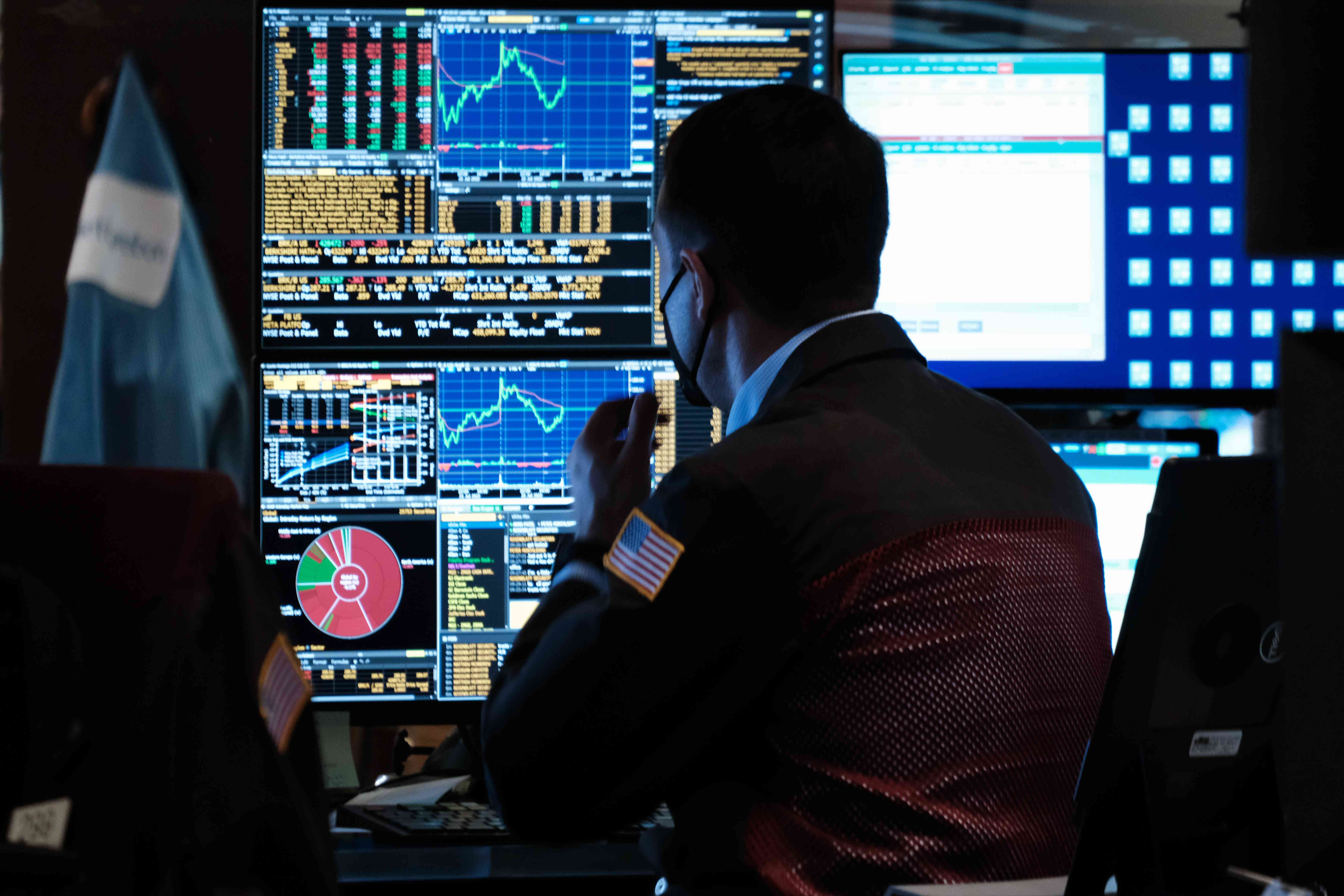 A trader looks at computers at the New York Stock Exchange
